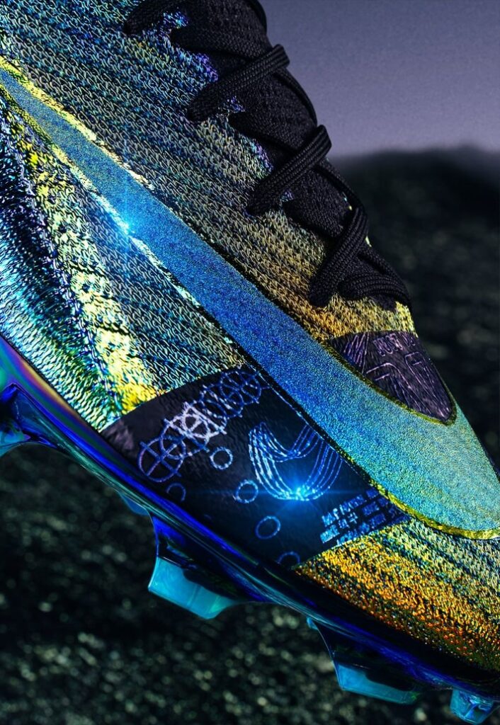 A Nike lançou a nova Air Zoom Mercurial 'Cosmic Speed', chuteiras em dourado e preto iridescente que destacam-se por seu design inovador e foco em velocidade. Parte da linha Mercurial, as novas Vapor XVI e Superfly X são usadas por jogadores como Vinícius Jr., Lauren James, Salma Paralluelo, e Sam Kerr, oferecendo um visual que muda de cor conforme o ângulo de visão. Utilizando a tecnologia PVD (Physical Vapor Deposition), o modelo celebra a agilidade no futebol e promete impactar tanto pelo estilo quanto pela performance em campo.